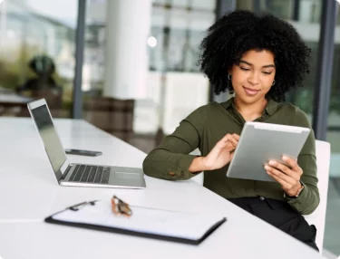 Woman comparing web hosting plans on tablet.