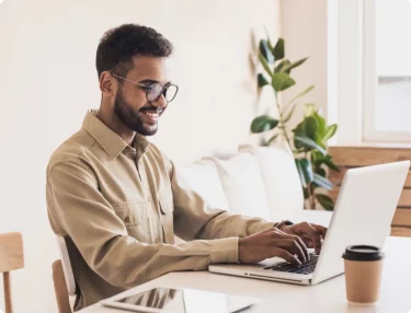 Man with laptop searching cheap domain names.