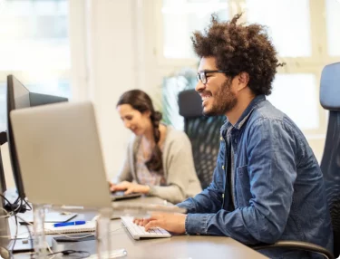 Man with monitors using one click installation to easily host website.